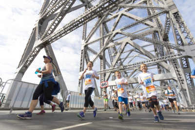 woman and two boys running across story bridge