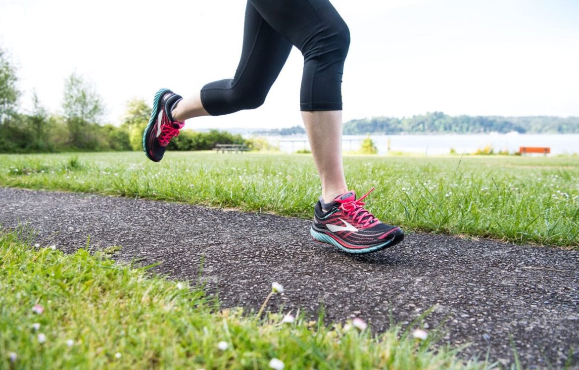 female running along path wearing brooks shoes
