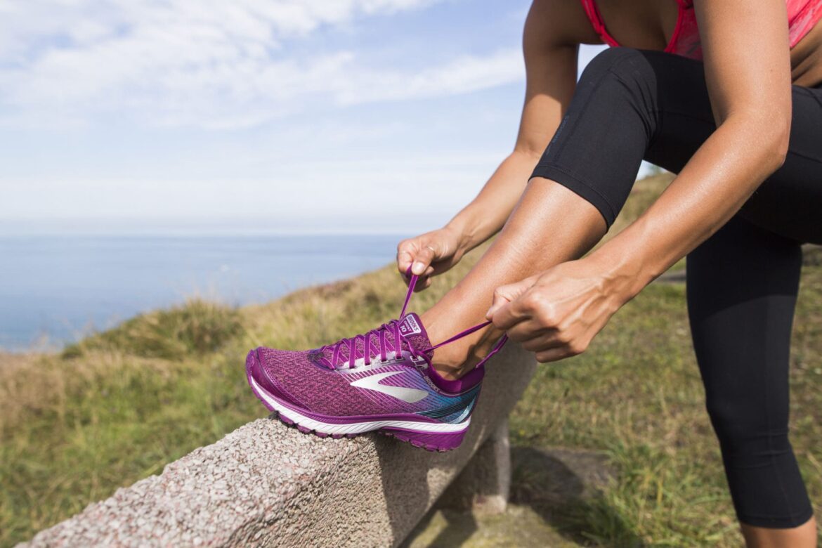 Female runner stops to tie shoelace